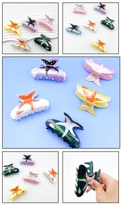 Detail view of large acrylic hair claw clips featuring ocean starfish and fish print designs