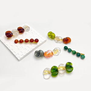 Artistic amber and resin beaded hair clips with gold metal base on white background