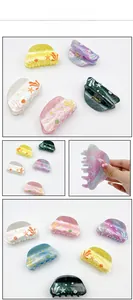 Macro detail of acrylic ocean-themed hair claws with colorful starfish and seaweed prints