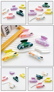 Macro detail of acrylic hair claws featuring ocean shell and seaweed prints in multiple colors