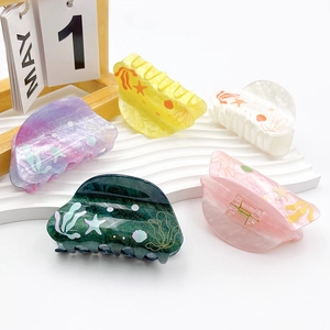 Colorful ocean theme shark hair clips with starfish and seagrass patterns on white stand