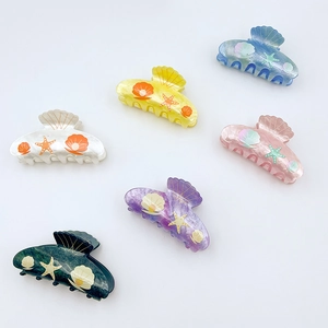 Set of six colorful ocean-themed hair claws featuring shell and starfish patterns on white background