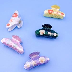 Ocean-themed acrylic hair claws with gold starfish and shell patterns in five colors