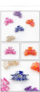 Detailed macro view of colorful acrylic butterfly hair claws with gold metal springs