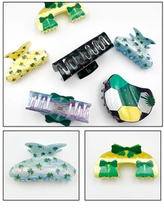 Detail view of acrylic hair claws with Saudi palm tree motifs and bow designs