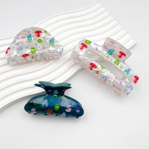 Three acrylic hair claws in semi-circle and rectangular shapes with letter print patterns