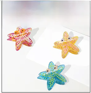 Detailed view of acetate starfish hair claws with polka dot patterns in pink and yellow
