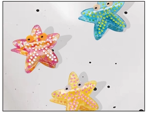 Detail view of starfish hair claws in blue, orange, and yellow with playful dot patterns