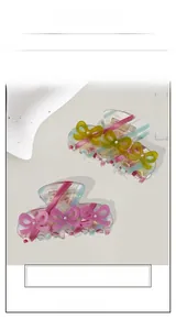 Détail de pinces à cheveux avec nœuds en acétate et perles aux couleurs pastel