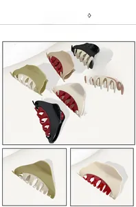 Detail of large claw clips in various colors including dark green, beige, and pink