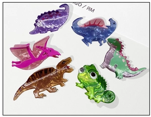 Detail view of 6 colorful dinosaur hair claws made of marble textured acetate fiber