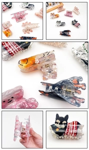 Detailed close-up of cartoon animal hair claw clips with focus on spring mechanism