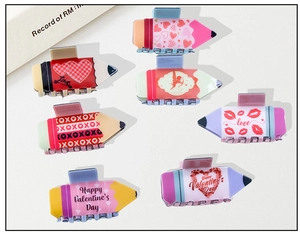 Flat lay of colorful pencil-shaped hair claws with Valentine's hearts and Love patterns