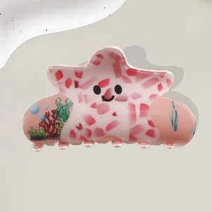Pink starfish hair claw clip with cute cartoon face and ocean patterns for women