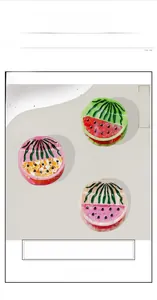Detailed macro view of large acetate fruit-themed hair claws in green and pink patterns