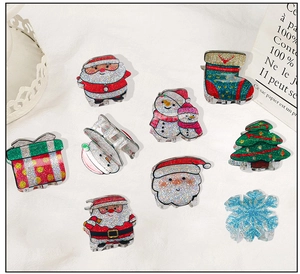 Dettaglio set mollette per capelli natalizie con Babbo Natale, pupazzo di neve e glitter