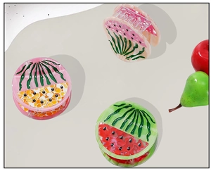 Detailed view of fruit-shaped acetate hair claws in watermelon and peach designs