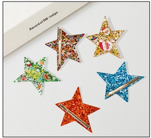 Close-up of star-shaped Christmas hair clips with sequins and festive holiday patterns