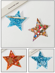 Close-up of star-shaped Christmas hair clips with glitter finish and metal fasteners