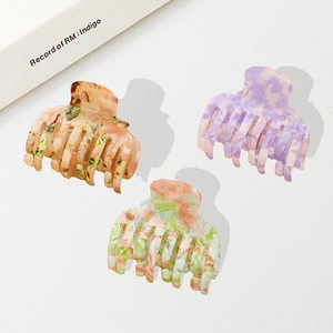 Lot de trois grandes pinces à cheveux en acétate coloré aux motifs marbrés et floraux