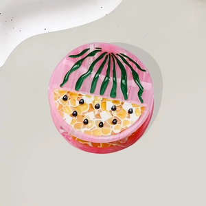 Pink and yellow fruit-themed acetate hair claw clip with colorful artistic patterns