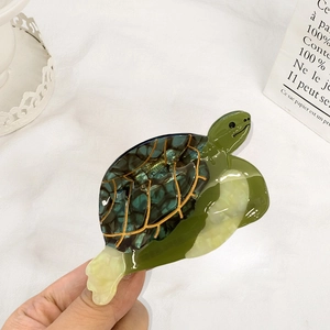 Pince à cheveux tortue élégante avec texture marbrée verte et accents dorés pour femmes