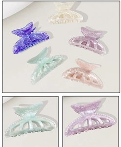 Detailed close-up of shell-shaped hair claws with imitation pearls in pastel colors