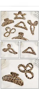 Various leopard print hair claw clips in star, bow, and geometric shapes on a white tray