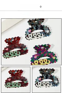Detail showing various colors of heart-shaped acetate hair claws with wave patterns