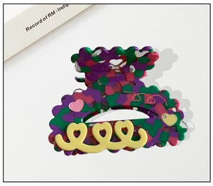 Close-up of heart-shaped floral cellulose acetate hair claw clip with colorful floral pattern