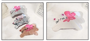 Détail des pinces à cheveux chat en acétate avec fleurs 3D et motifs élégants en marbre