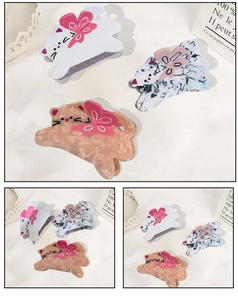 Détail de trois pinces à cheveux chat en acétate blanc, marbré et rose avec petites fleurs