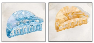 Detailed close-up showing acetate shark hair clips with blue and yellow marble patterns