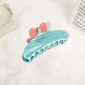 Teal acetate hair claw clip with pink bow flower design on soft white background