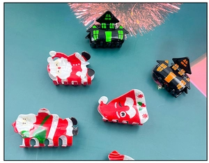Detailed flat lay of Santa Claus and castle hair claw clips for holiday hairstyling