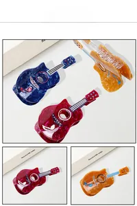 Detailed view of guitar hair claws with musical notes and colorful rhinestones