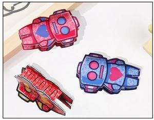 Close-up of quirky robot hair claw clips with marble texture and heart pattern detail