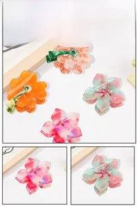 Detailed close-up showing four floral acetate hair claws with marble textures and small rhinestones