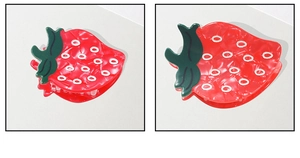 Detail view of a cute red strawberry hair claw clip made of glossy acetate resin material