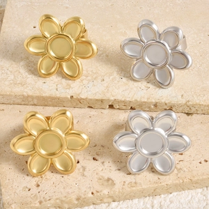 Detailweergave van bloemvormige roestvrijstalen ringen in goud en zilver finish