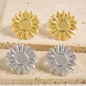 Vue détaillée de boucles d'oreilles marguerites en or et argent sur pierre