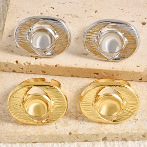 Macro detail of chunky oval dome rings with radial texture on beige stone background