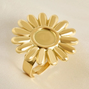 Détail macro d'une bague fleur dorée avec anneau réglable sur fond de soie douce