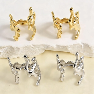 Macro detail of irregular liquid metal coral rings in gold and silver finish on stones