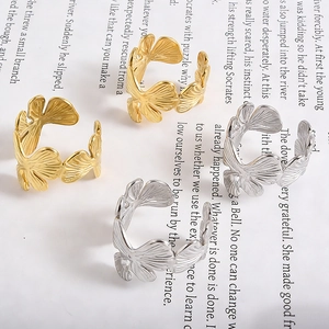 Artistic layout of golden and silver ginkgo leaf open rings on a vintage book background