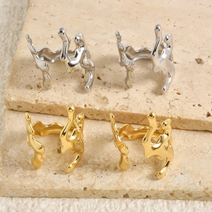 Detailed macro view of gold and silver irregular coral rings on beige travertine steps