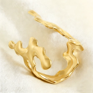 Macro detail of irregular gold coral ring with polished lava texture on silk fabric