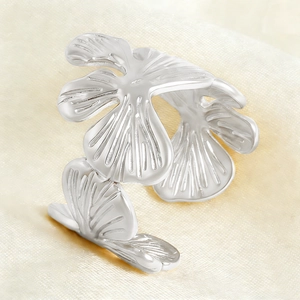 Macro detail of the silver butterfly leaf ring showing textured metal and open band design