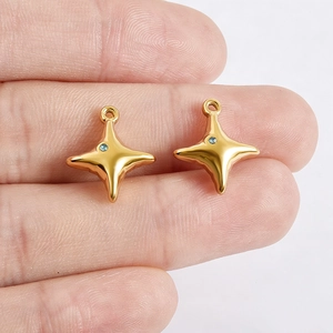 Macro view of gold stainless steel star pendants with blue zircon on fingers