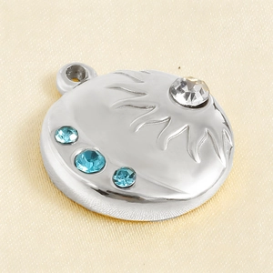 Macro shot of sunburst stainless steel pendant with blue and clear rhinestones